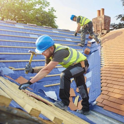 Two men hammering on roof
