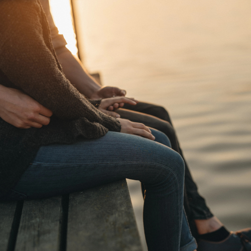 Couple's legs at edge of pier