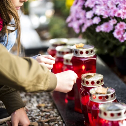 Mother and daughter lighting candles at remembrance site