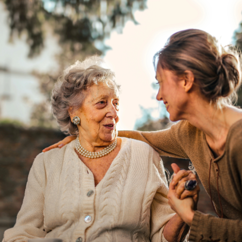 Elderly woman speaking with younger woman