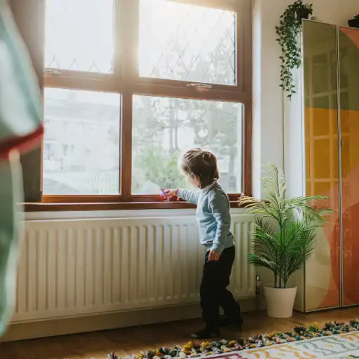 Child playing with toy on windowsil