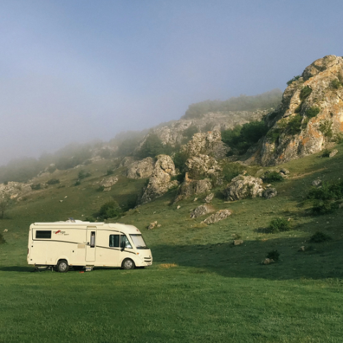 Motorhome in field next to rocky hill