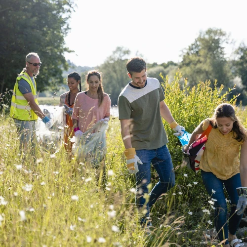 Small group of people picking litter from field