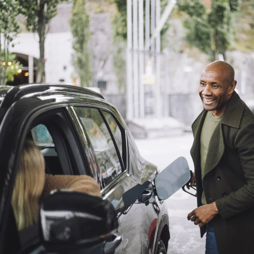 Man smiling filling car at petrol station