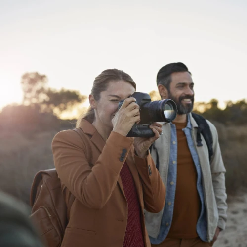 Woman and man smiling taking photo with camera