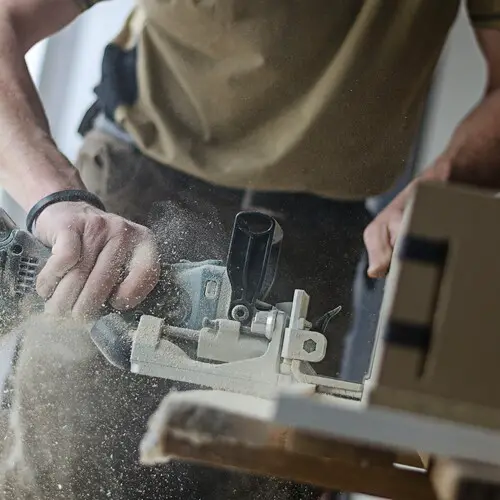 A carpenter using a tool whilst on the job