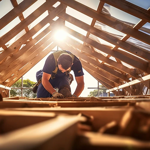 A tradesman working on timber framing whilst backed by a public liability insurance policy